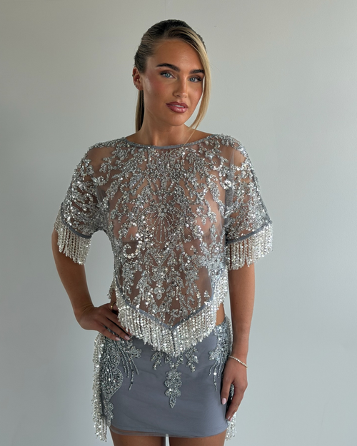 A woman modeling a Maison Lyssa, The Alice Tassel Skirt, an embellished tassle skirt
